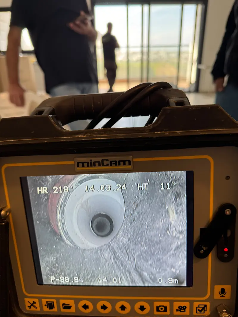 מסך מצלמת סיב מקצועית מציג צילום פנים של צנרת, בדירה במגדל חדש